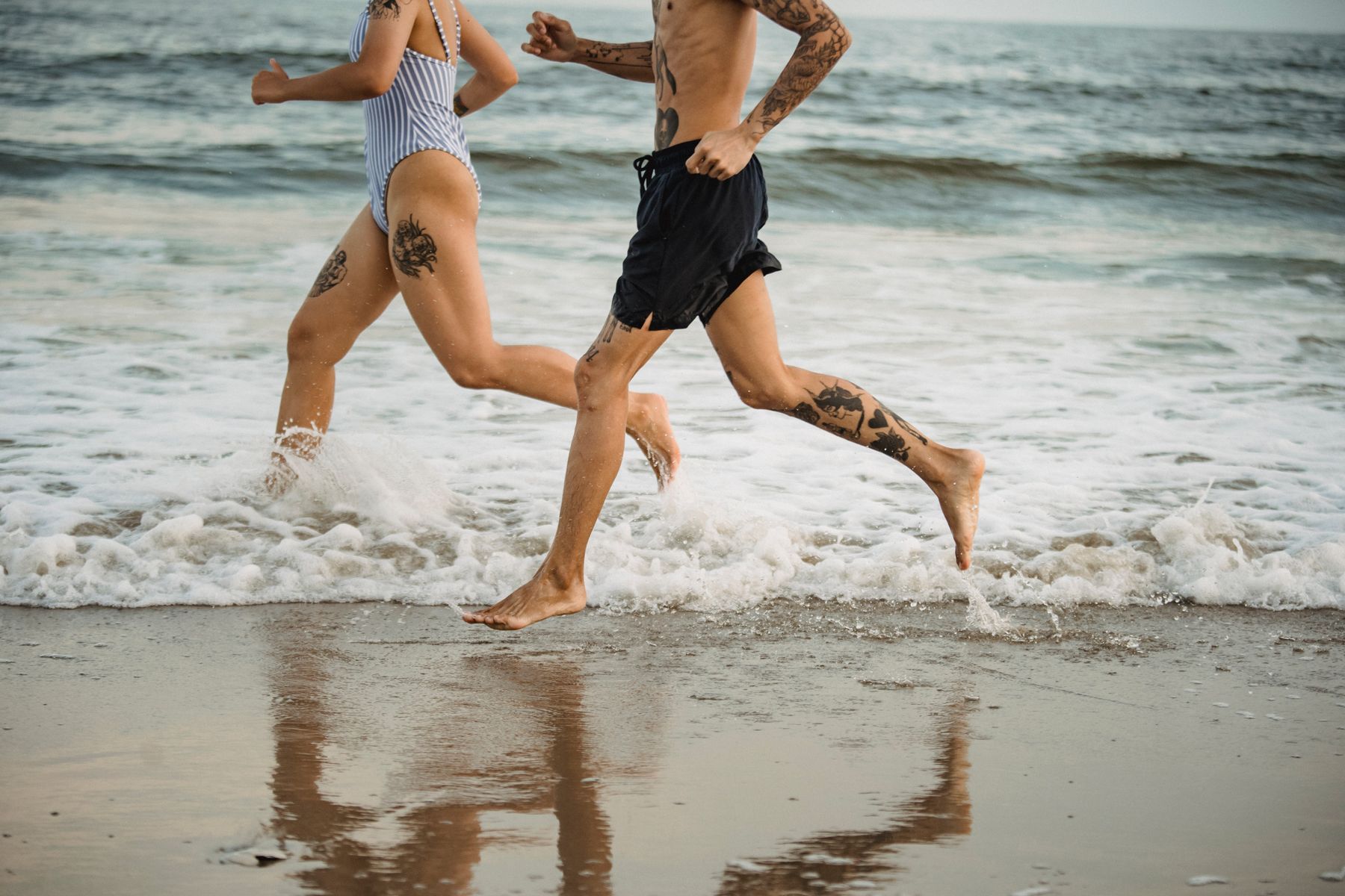 Two people running through the surf