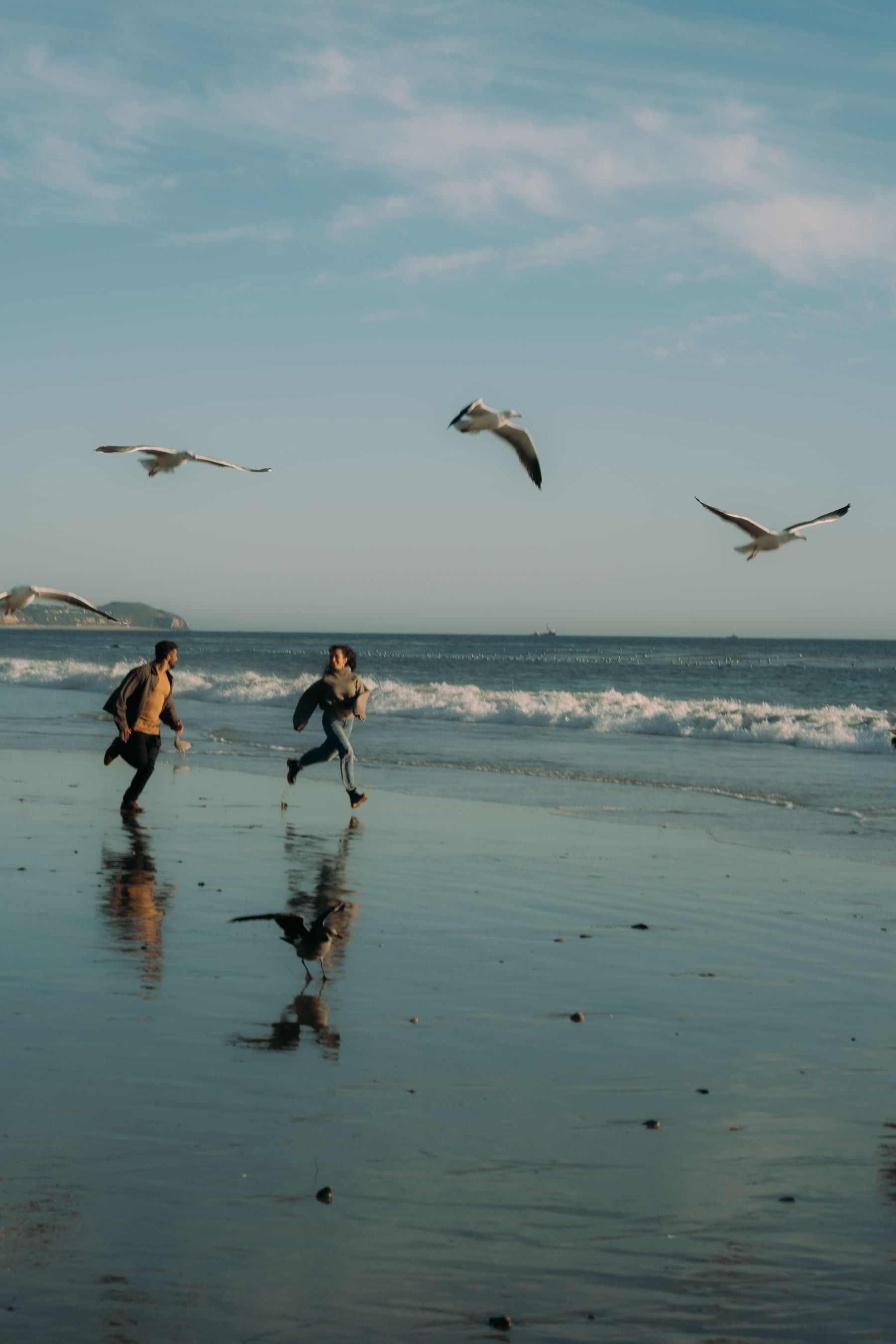 Two friends running beside the California coast