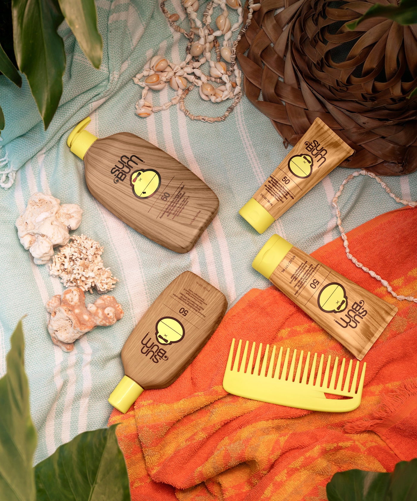 Official Sun Bum SPF 50 products arranged on colorful beach towels